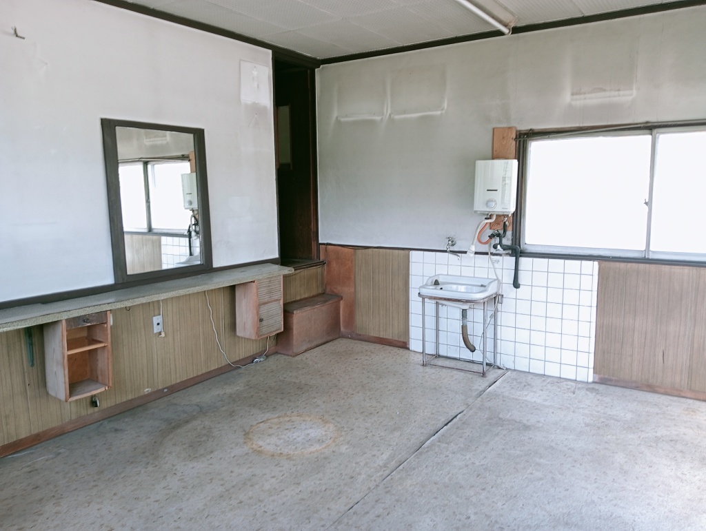 2-story residential building with many rooms on a south-facing open plot adjacent to a national highway. Suitable for dual-family housing or private lodging use.