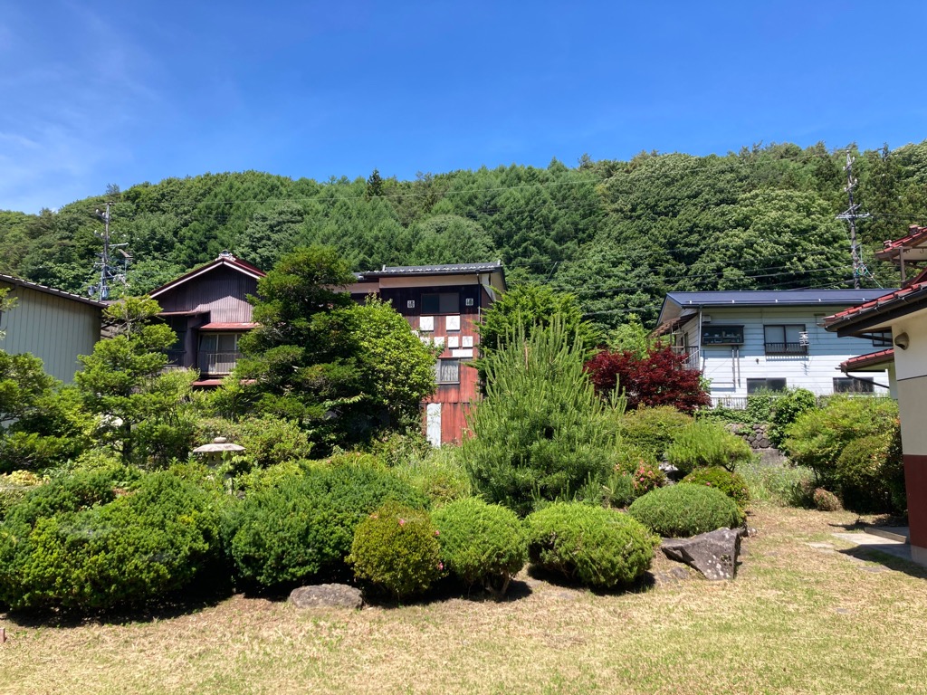 2-story residential building with many rooms on a south-facing open plot adjacent to a national highway. Suitable for dual-family housing or private lodging use.