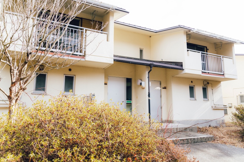 2-story residential building with many rooms on a south-facing open plot adjacent to a national highway. Suitable for dual-family housing or private lodging use.