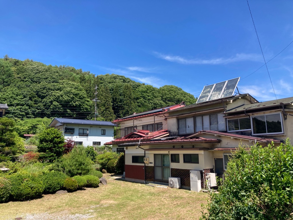 2-story residential building with many rooms on a south-facing open plot adjacent to a national highway. Suitable for dual-family housing or private lodging use.