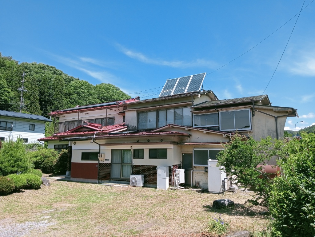 2-story residential building with many rooms on a south-facing open plot adjacent to a national highway. Suitable for dual-family housing or private lodging use.