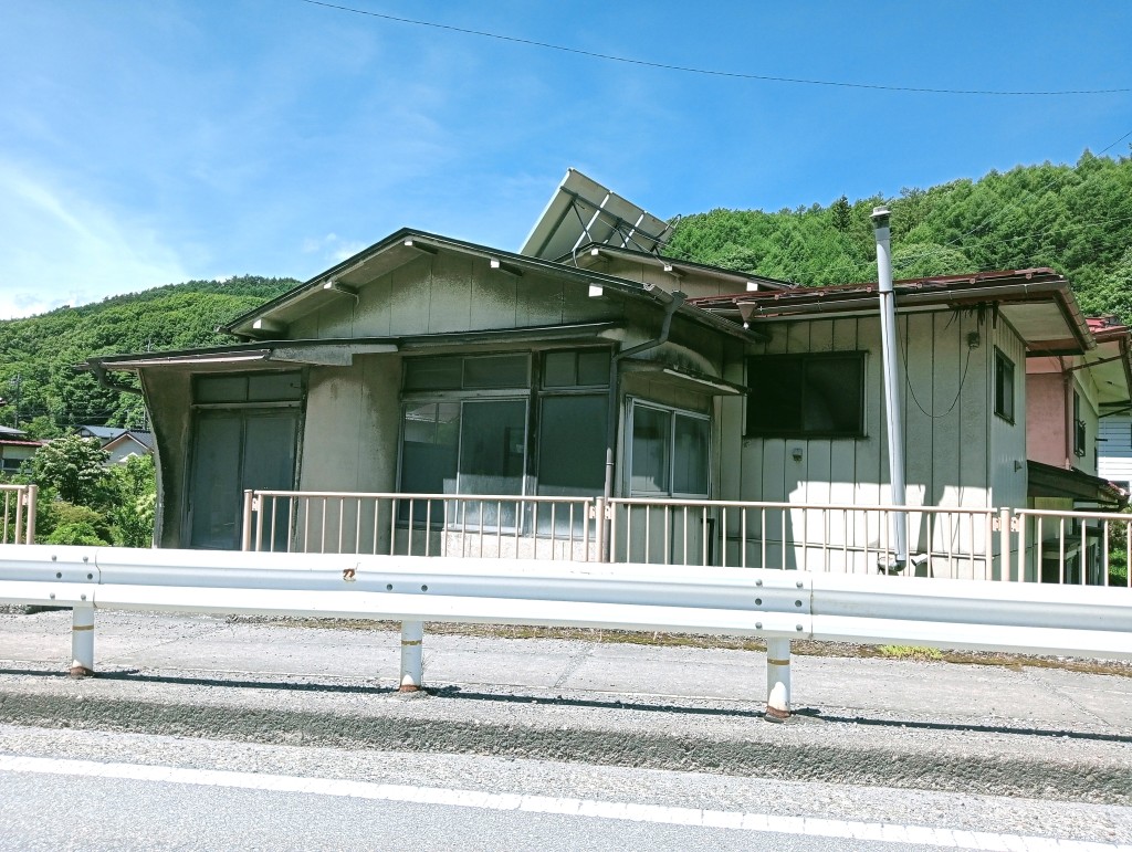 2-story residential building with many rooms on a south-facing open plot adjacent to a national highway. Suitable for dual-family housing or private lodging use.